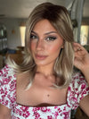 Roxie wearing HARLOW by NORIKO in MELTED-MARSHMALLOW | Subtly Warm Dark Sandy Blonde Blend with Medium Brown Roots and Light Ash Blonde Tips and Highlights