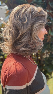 Eileen wearing HELSINKI by BELLETRESS in MACADAMIA LATTE R | A combination of Medium and Light Brown, highlighted with Light Gold Blonde, and a mixture of Ash Blonde and Light Gold Blonde, Rooted with Medium and Light Brown