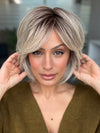 Roxie wearing WINTOUR by BELLETRESS in COOL CHAI BLONDE-R | A balanced cool blonde with softly contrasted darker roots, a fresh twist on classic blonde tones.