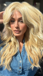 Roxie is wearing California Beach Waves by TressAllure in shade 223/23C | Light Golden Blonde
