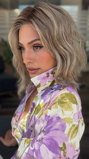 Roxie is wearing VERONICA by BELLETRESS in SPARKLING CHAMPAGNE BLONDE R | A radiant blend of champagne blonde with soft golden and beige tones, grounded by natural-looking roots in ash brown and dark blonde.