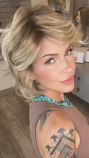 Madeline wearing MONROE by BELLETRESS in BUTTERCAKE BLONDE-R | A neutral-warm blonde blend featuring light brown, ash, and lightest blonde tones with natural-looking darker roots for added depth and realism.