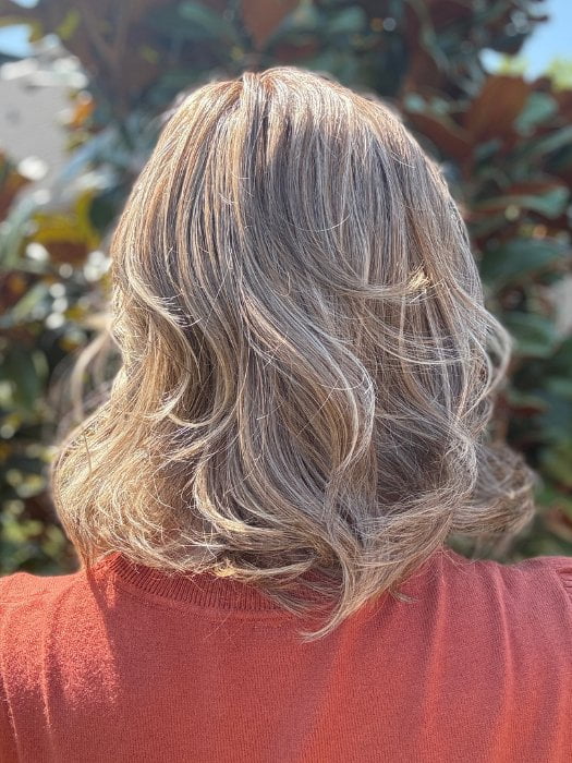 Eileen wearing HELSINKI by BELLETRESS in MACADAMIA LATTE R | A combination of Medium and Light Brown, highlighted with Light Gold Blonde, and a mixture of Ash Blonde and Light Gold Blonde, Rooted with Medium and Light Brown