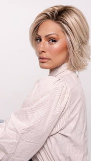 Roxie wearing ALICANTE by BELLETRESS in CRUSHED ALMOND BLONDE R | A soft Neutral Light Blonde with a Light and Medium Blended Root Color.