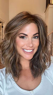 Katy C. @thewigeducator wearing WAVY DAY by RAQUEL WELCH WIGS in color RL8/29SS SHADED HAZELNUT | Warm Medium Brown Evenly Blended with Ginger Blonde with Dark Roots | window lighting