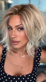 Roxie wearing NEWPORT by BELLETRESS in CRUSHED ALMOND BLONDE R | A soft Neutral Light Blonde with a Light and Medium Blended Root Color.