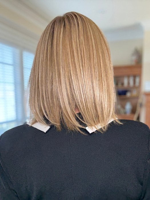 Eileen wearing PAIGE PETITE by ENVY in SPARKLING CHAMPAGNE | Medium Brown roots with overall Strawberry Blonde base and soft Golden Blonde highlights