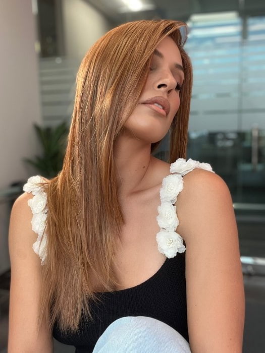 Roxie is wearing CHAMPION by BELLE TRESS in color AUBURN SPICE R | A Deep Auburn Shade with Darker Roots and subtle highlights in Copper and Golden Spice Tones