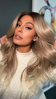 Roxie wearing ALLURE WAVEZ by RENE OF PARIS in  MELTED-MARSHMALLOW | Subtly Warm Dark Sandy Blonde Blend with Medium Brown Roots and Light Ash Blonde Tips and Highlights