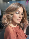 Model is wearing AVALON by ESTETICA in color CINDER HEAT | Reddish brown base blended with smoked copper with soft amber highlights and chestnut brown roots.