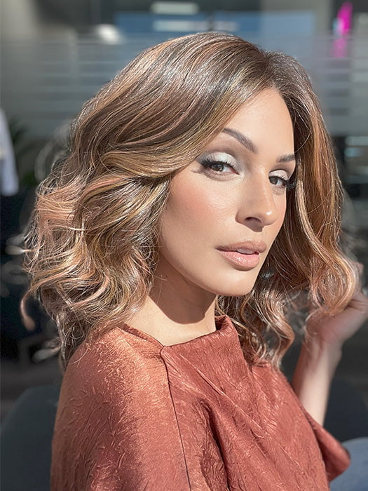 Model is wearing AVALON by ESTETICA in color CINDER HEAT | Reddish brown base blended with smoked copper with soft amber highlights and chestnut brown roots.