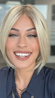 Model is wearing AYUMI by NORIKO in color Light Ash Blond R | Cream Ash Blonde with ash brown and white-grey roots that blend into a variety of ash blonde tones, including ash pearl blonde, creamy ivory, and pale cream