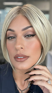 Model is wearing AYUMI by NORIKO in color Light Ash Blond R | Cream Ash Blonde with ash brown and white-grey roots that blend into a variety of ash blonde tones, including ash pearl blonde, creamy ivory, and pale cream