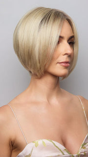 Model is wearing AYUMI by NORIKO in color Light Ash Blond R | Cream Ash Blonde with ash brown and white-grey roots that blend into a variety of ash blonde tones, including ash pearl blonde, creamy ivory, and pale cream