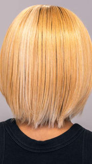 Model is wearing ARIA by RENE OF PARIS in shade PEACHES-AND-CREAM | A vibrant peach blonde with creamy undertones and bright, face-framing cream highlights. Rich chocolate root adds depth.