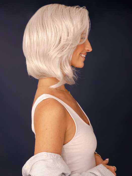 Model is wearing SHEENA by RENE OF PARIS in color GHOST-BLONDE-R | Medium neutral blond roots fade into a pearl cream blond shade with platinum blond undertones.