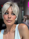 Model is wearing CURATED CUT by RAQUEL WELCH in color RL19/23SS SHADED BISCUIT | Light Ash Blonde Evenly Blended with Cool Platinum Blonde with Dark Roots