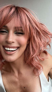 Model is wearing BREEZY WAVEZ by RENE OF PARIS in color DUSTY-ROSE | Medium Coral Red Base with Dark Brown Roots