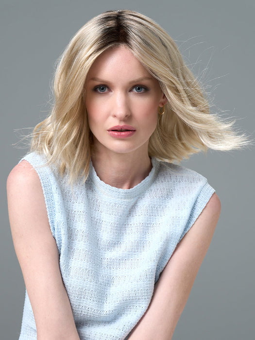 Model is wearing Charlotte Petite by ENVY in color SILKY BEIGE |  Light Platinum Blonde with Dark Brown Roots
