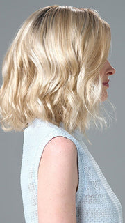 Model is wearing Charlotte Petite by ENVY in color SILKY BEIGE |  Light Platinum Blonde with Dark Brown Roots