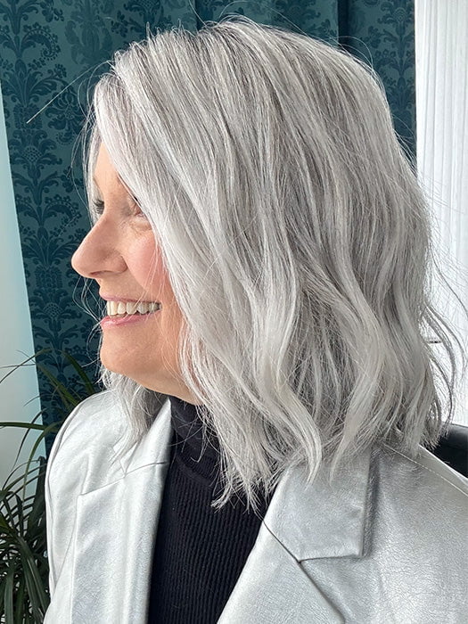 Mel B. @mels.be.ageless wearing CHARLOTTE PETITE by ENVY in color STERLING SHADOW | Medium Salt-and-Pepper Grey with Darker Brown Roots