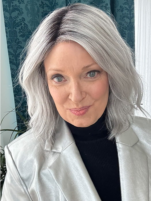 Mel B. @mels.be.ageless wearing CHARLOTTE PETITE by ENVY in color STERLING SHADOW | Medium Salt-and-Pepper Grey with Darker Brown Roots