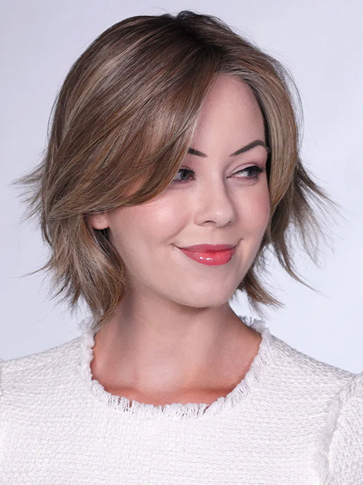 Model is wearing FERRARI By BELLETRESS in color SUNKISSED ALMOND R | A blend of Medium and Light Brown with Light Gold Blonde Highlights and a hint of Cooler Blonde, rooted with Medium and Light Brown