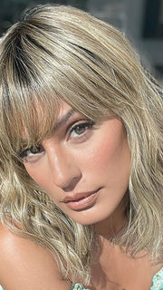 Model is wearing FRANKIE by ESTETICA in color RH12/26RT4 | Light Brown with Fine Golden Blonde Highlights And Dark Roots