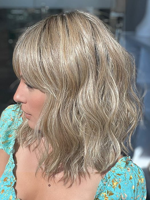 Model is wearing FRANKIE by ESTETICA in color RH12/26RT4 | Light Brown with Fine Golden Blonde Highlights And Dark Roots