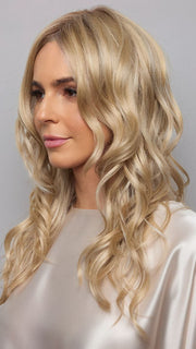 Model is wearing HANA by NORIKO in color Light Ash Blond R | Cream Ash Blonde with ash brown and white-grey roots that blend into a variety of ash blonde tones, including ash pearl blonde, creamy ivory, and pale cream