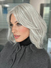 Roxie is wearing HOLLIE PETITE by JON RENAU in shade 56F51 OYSTER | Light Grey with 20% Medium Brown Front, graduating to Grey with 30% Medium Brown Nape 