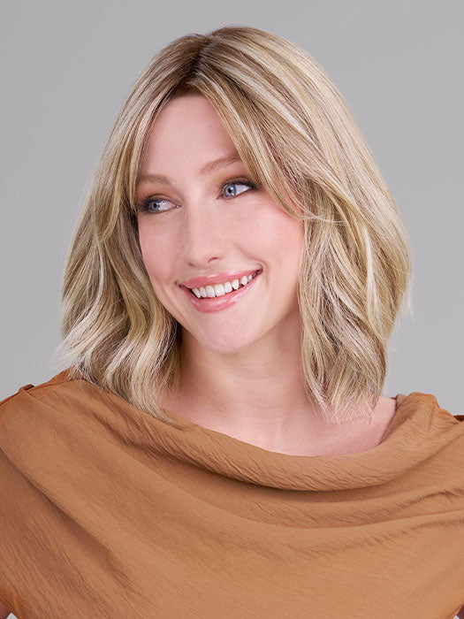 Model is wearing HOLLIE PETITE by JON RENAU in color 12FS12 MALIBU BLONDE | Light Gold Brown, Light Natural Gold Blonde, Pale Natural Gold-Blonde Blend, Shaded with Light Gold Brown