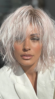 Model is wearing JONES by ESTETICA in color POLARIZING PINK | Icy platinum blonde blended with soft rose and silver undertones. Medium ash brown roots add dimension and depth.