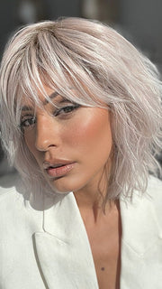 Model is wearing JONES by ESTETICA in color POLARIZING PINK | Icy platinum blonde blended with soft rose and silver undertones. Medium ash brown roots add dimension and depth.