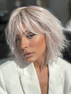 Model is wearing JONES by ESTETICA in color POLARIZING PINK | Icy platinum blonde blended with soft rose and silver undertones. Medium ash brown roots add dimension and depth.