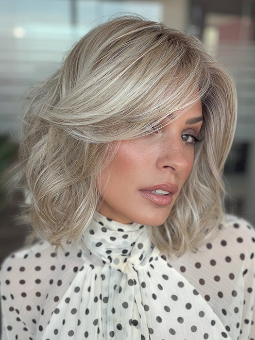 Model is wearing LORYN in color SEA SALT BLOND R | A perfect mixture of cool, icy-blond and warm-dark blond. The rich brown root tone enhances the modern appearance
