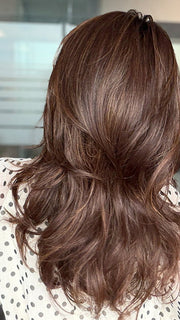 Roxie is wearing MARGO in color GLAZED AUBURN R | Stunning fusion of deep red, medium copper, and dark chocolate root.