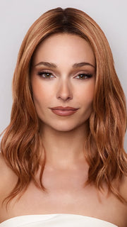 Model is wearing MAUDE by Amore in color RUSTY-SUNRISE-R | Dark brown roots transition into a deep auburn tone with light copper blonde highlights for depth and dimension.