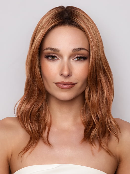 Model is wearing MAUDE by Amore in color RUSTY-SUNRISE-R | Dark brown roots transition into a deep auburn tone with light copper blonde highlights for depth and dimension.