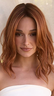 Model is wearing MAUDE by Amore in color RUSTY-SUNRISE-R | Dark brown roots transition into a deep auburn tone with light copper blonde highlights for depth and dimension.
