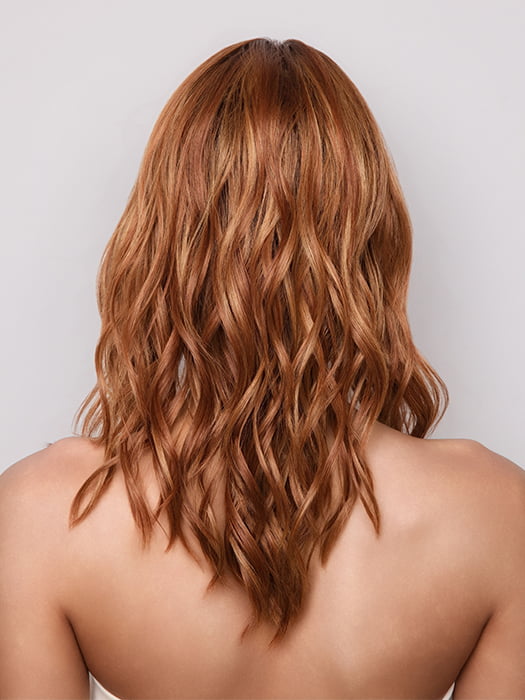 Model is wearing MAUDE by Amore in color RUSTY-SUNRISE-R | Dark brown roots transition into a deep auburn tone with light copper blonde highlights for depth and dimension.