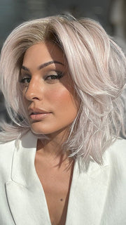 Model is wearing MELLOW by ESTETICA in color POLARIZING PINK | Icy platinum blonde blended with soft rose and silver undertones. Medium ash brown roots add dimension and depth.