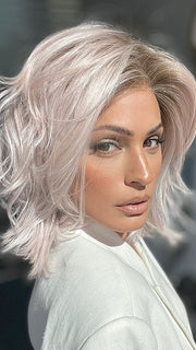 Model is wearing MELLOW by ESTETICA in color POLARIZING PINK | Icy platinum blonde blended with soft rose and silver undertones. Medium ash brown roots add dimension and depth.
