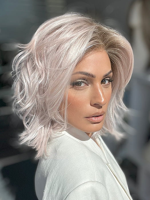 Model is wearing MELLOW by ESTETICA in color POLARIZING PINK | Icy platinum blonde blended with soft rose and silver undertones. Medium ash brown roots add dimension and depth.