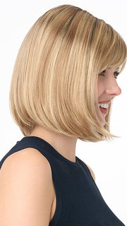 Model is wearing PAIGE PETITE by ENVY in color SPARKLING CHAMPAGNE | Medium Brown roots with overall Strawberry Blonde base and soft Golden Blonde highlights