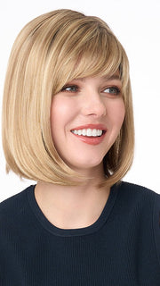 Model is wearing PAIGE PETITE by ENVY in color SPARKLING CHAMPAGNE | Medium Brown roots with overall Strawberry Blonde base and soft Golden Blonde highlights