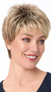 Model is wearing PENELOPE by ENVY in color SPARKLING CHAMPAGNE | Medium Brown roots with overall Strawberry Blonde base and soft Golden Blonde highlights