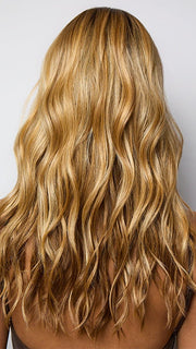 Model is wearing POSH WAVEZ in Bronzed Honey-R  | A perfect blend of rich, warm golden blond and medium chocolate brown tones, complemented by a dark chocolate root that adds a luxurious, dimensional effect.