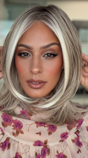 Roxie is wearing DREW by JON RENAU in 101/88/27S8 CATALINA BLONDE | Pale blonde with Pure White Natural Violet halo highlights, shaded medium brown