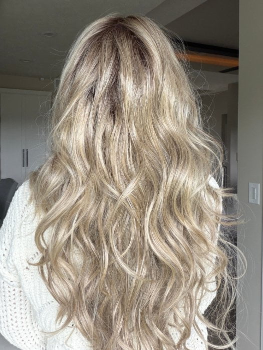 Carly wearing CAROLINA by BELLETRESS in SPARKLING CHAMPAGNE R | Medium Ash Brown roots transition into Shimmering Champagne Blonde characterized by Pale Golden Hues with subtle Ivory and Platinum undertones reminiscent of a sparkling glass of bubbly